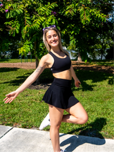 Load image into Gallery viewer, Black sports bra with medium-high support, standard neckline and strappy back