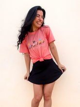 Load image into Gallery viewer, Pink graphic t-shirt with 3 pairs of colorful rollerskates and the phrase "let's go girls" printed underneath