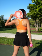 Load image into Gallery viewer, Orange colored sports bra with medium to high support and a unique racerback cut