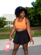 Load image into Gallery viewer, Orange colored sports bra with medium to high support and a unique racerback cut