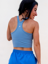 Load image into Gallery viewer, Young lady modeling a sky blue cropped racerback spandex tank with a built-in sports bra.