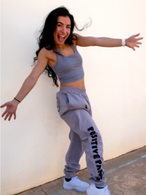Load image into Gallery viewer, Peachy Pia Positive Pants joggers. Grey lightweight jogger sweatpants with positive pants design down the front of the right leg and smiley face design on the back pocket. Joggers provide an elastic waist and cuffed ankles.