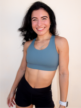 Load image into Gallery viewer, Stone green colored strappy sports bra with an open back and standard neckline that provides medium support.