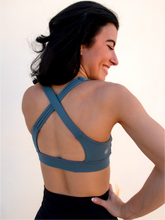 Load image into Gallery viewer, Stone green colored strappy sports bra with an open back and standard neckline that provides medium support.