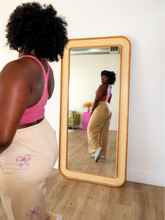 Load image into Gallery viewer, Pink cropped tank top with a built-in sports bra and bow design on the front paired with tan sweatpants with pink bow pattern