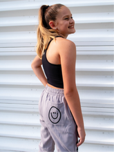 Load image into Gallery viewer, Peachy Pia Positive Pants joggers. Grey lightweight jogger sweatpants with positive pants design down the front of the right leg and smiley face design on the back pocket. Joggers provide an elastic waist and cuffed ankles.