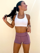 Load image into Gallery viewer, Young lady modeling Peachy Pia Peachy Shorts. Peachy Shorts are high-waisted in color lilac purple with a 75% nylon, 25% spandex blend. Extra stretchy fabric provides extra comfort while still providing a more fitted appearance.