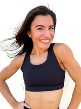 Load image into Gallery viewer, Lady modeling unique style black racerback sports bra.