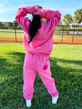 Load image into Gallery viewer, Pink unisex baggy joggers with a dark pink hand-illustrated peach on the back right pocket