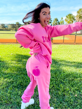 Load image into Gallery viewer, Pink unisex baggy joggers with a dark pink hand-illustrated peach on the back right pocket