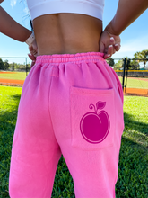 Load image into Gallery viewer, Pink unisex baggy joggers with a dark pink hand-illustrated peach on the back right pocket