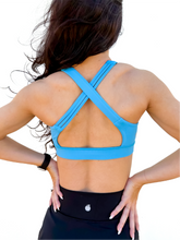 Load image into Gallery viewer, Lady modeling sky blue strappy sports bra.