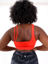 Load image into Gallery viewer, The Striking Sports Bra is a one shoulder, apple red sports bra with additional straps for added support and comes in a creamy soft material.