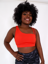Load image into Gallery viewer, The Striking Sports Bra is a one shoulder, apple red sports bra with additional straps for added support and comes in a creamy soft material.