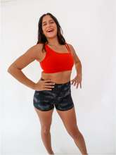 Load image into Gallery viewer, The Striking Sports Bra is a one shoulder, apple red sports bra with additional straps for added support and comes in a creamy soft material.