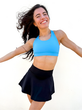 Load image into Gallery viewer, Lady modeling black tennis skort with built in side pocket.