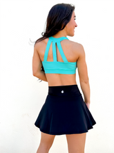 Load image into Gallery viewer, Lady modeling black tennis skort with built in side pocket.