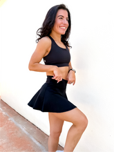 Load image into Gallery viewer, Lady modeling black tennis skort with built in side pocket.