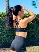 Load image into Gallery viewer, Black sports bra with medium support, removable pads and a criss cross back