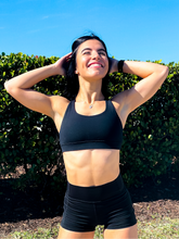 Load image into Gallery viewer, Black sports bra with medium support, removable pads and a criss cross back