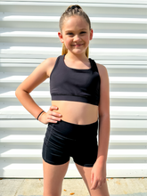 Load image into Gallery viewer, Young girl modeling black unique racerback style sports bra.