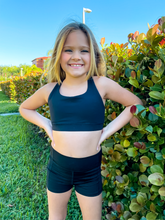 Load image into Gallery viewer, Kids black sports bra with simple front and cute criss cross back