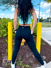 Load image into Gallery viewer, Young lady modeling black buttery soft leggings in black with two side pockets