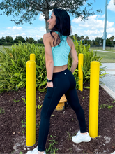 Load image into Gallery viewer, Young lady modeling black buttery soft leggings in black with two side pockets