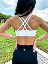 Load image into Gallery viewer, Young lady modeling Peachy Pia Worldwide Sports Bra. Sports bra is in color white with an 87% nylon, 13% spandex blend. Material is thick but flexible made to provide support and comfort.