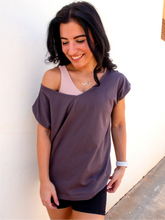 Load image into Gallery viewer, Young lady modeling a boxy, off-the-shoulder cotton/polyester dark grey t-shirt with a wide v-neck.
