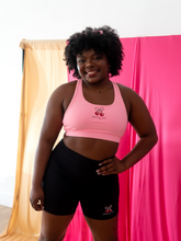 Load image into Gallery viewer, Light pink sports bra with a cherry bow design on the front and a strappy back
