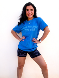 Blue graphic t-shirt with a whimsical "happy go lucky type vibe" design.