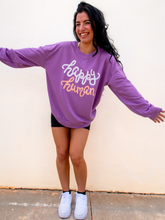 Load image into Gallery viewer, Young lady modeling a purple lightweight, crewneck sweatshirt with a hand-lettered script design saying &quot;happy human&quot; on the front in white and peach.
