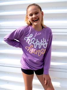 Young girl modeling a purple lightweight, crewneck sweatshirt with a hand-lettered script design saying "happy human" on the front in white and peach.