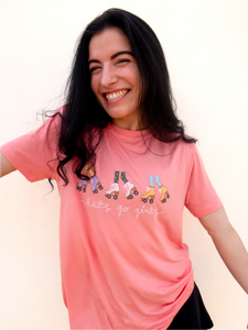 Pink graphic t-shirt with 3 pairs of colorful rollerskates and the phrase "let's go girls" printed underneath