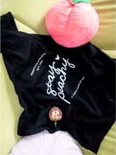 Load image into Gallery viewer, Oversized black zip up hoodie with Stay Peachy on the back with white and pink details
