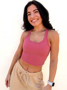 Young lady modeling a pink cropped racerback spandex tank with a built-in sports bra.