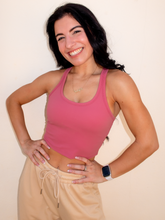 Load image into Gallery viewer, Young lady modeling a pink cropped racerback spandex tank with a built-in sports bra.
