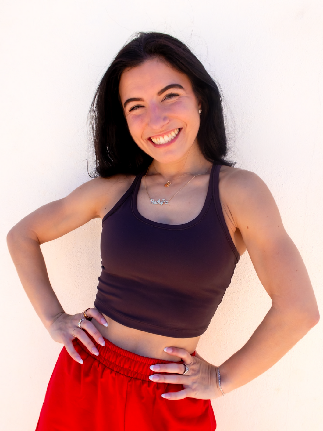 Young lady modeling a dark gray cropped racerback spandex tank with a built-in sports bra.