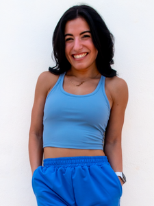 Young lady modeling a sky blue cropped racerback spandex tank with a built-in sports bra.