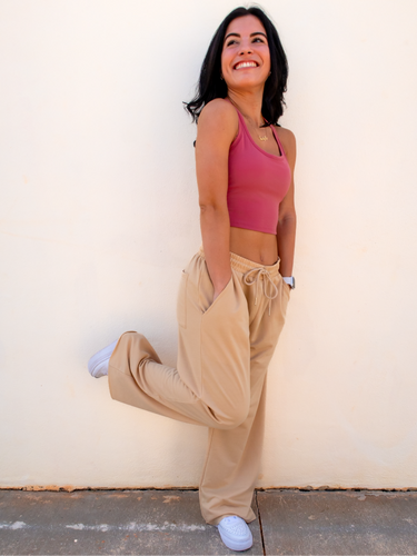 Young lady modeling tan colored wide-leg, lightweight sweatpants with a raw cut hem.