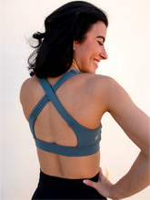 Load image into Gallery viewer, Stone green colored strappy sports bra with an open back and standard neckline that provides medium support.
