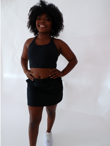 The Complimentary SweatSkirt has an outer skirt built with an elastic waistband and pockets. The Skirt has built-in spandex shorts and a happy message on the tag. Skirt is in color black.