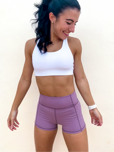 Young lady modeling Peachy Pia Peachy Shorts. Peachy Shorts are high-waisted in color lilac purple with a 75% nylon, 25% spandex blend. Extra stretchy fabric provides extra comfort while still providing a more fitted appearance.