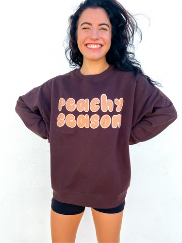 Brown oversized crewneck sweatshirt made of 80% cotton, 20% polyester, displaying a hand-drawn design for fall.