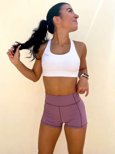 Young lady modeling Peachy Pia Peachy Shorts. Peachy Shorts are high-waisted in color lilac purple with a 75% nylon, 25% spandex blend. Extra stretchy fabric provides extra comfort while still providing a more fitted appearance.