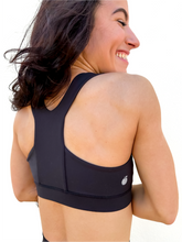 Load image into Gallery viewer, Lady modeling unique style black racerback sports bra.
