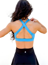 Load image into Gallery viewer, Lady modeling sky blue strappy sports bra.
