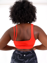 Load image into Gallery viewer, The Striking Sports Bra is a one shoulder, apple red sports bra with additional straps for added support and comes in a creamy soft material.
