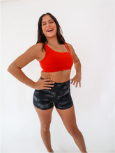 Load image into Gallery viewer, The Striking Sports Bra is a one shoulder, apple red sports bra with additional straps for added support and comes in a creamy soft material.
